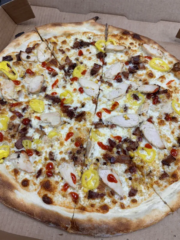 Whole white pizza cut into slices in a takeout box